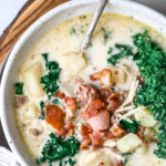 Photo of cheeseburger soup with crispy bacon and kale visible.