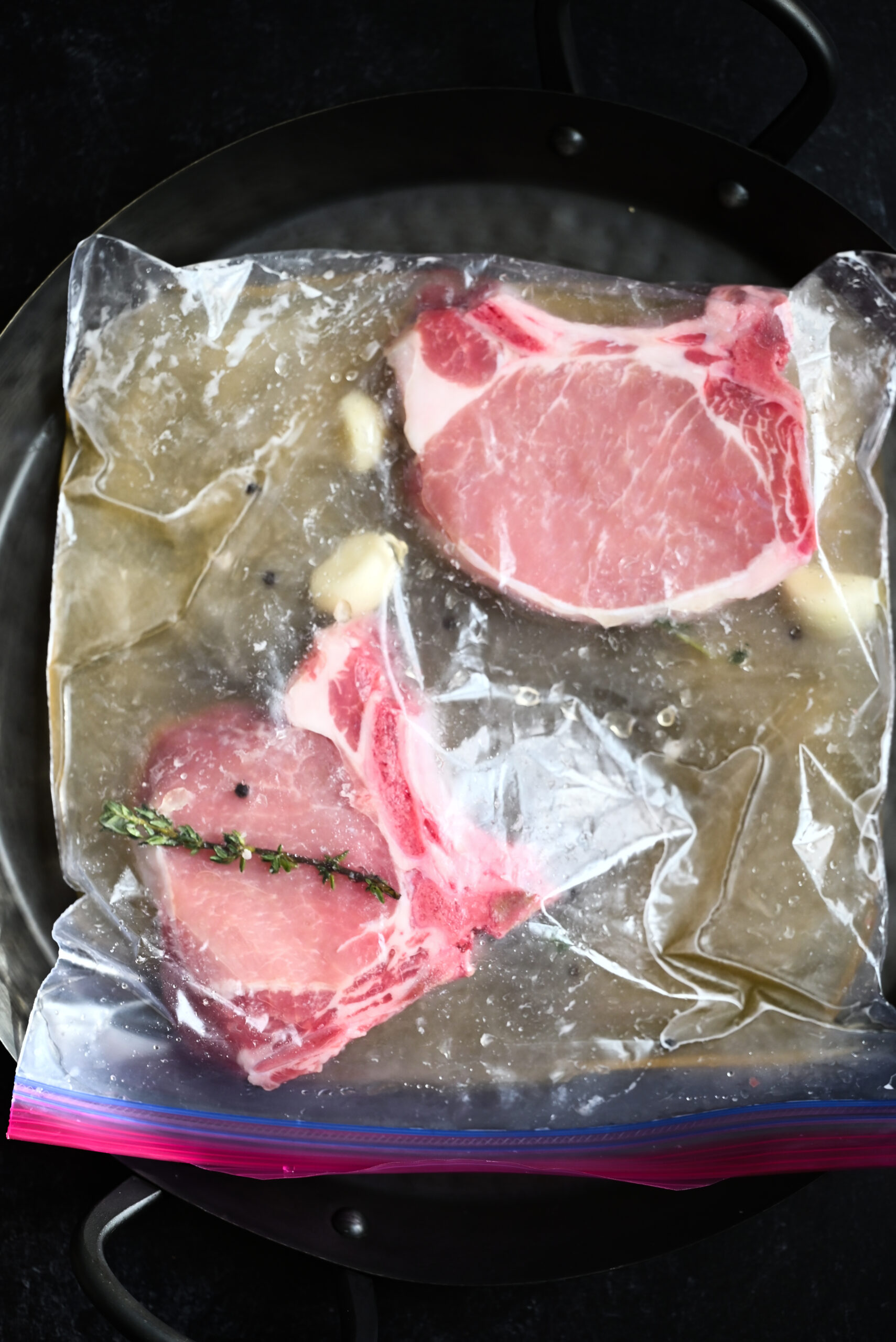 Pork chops laying flat in the brine (process shot). 