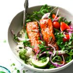 Photo of air fryer salmon on a bowl of rice and salad