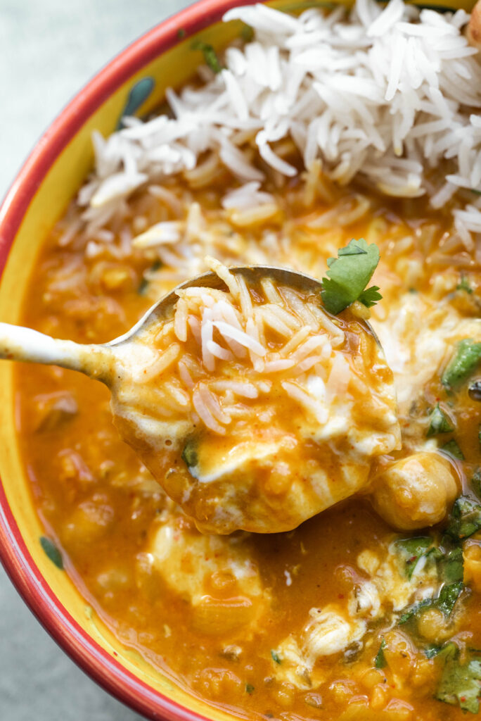 Spoon filled with Chickpea and Lentil Curry with rice. 