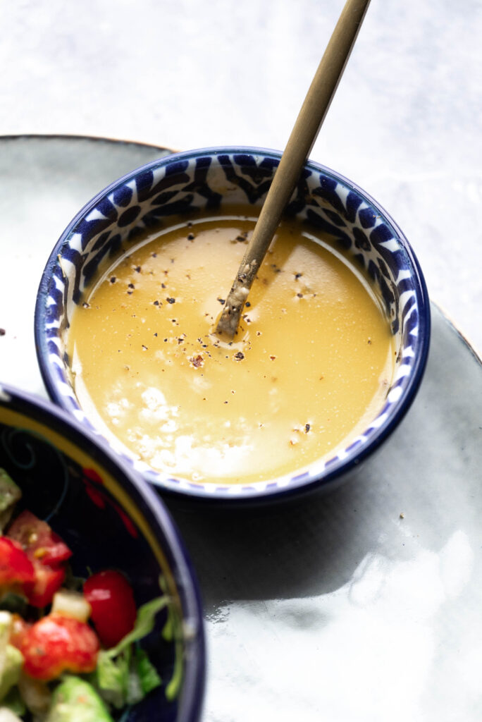 How to make Creamy hummus dressing - hero shot of the dressing in a small blue bowl.