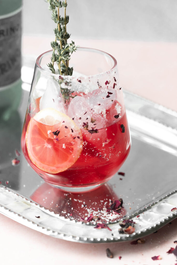 Wine glass filled with ice and brewed rose tea. 