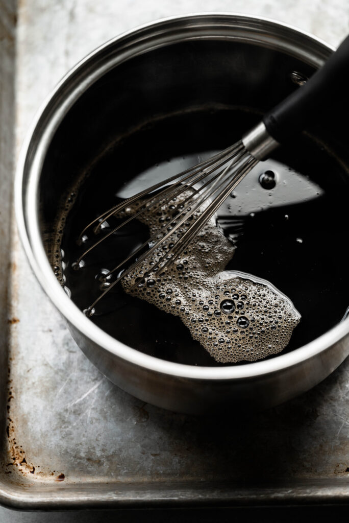 Ingredient shot of brown sugar syrup simmering in a sauce pan. 