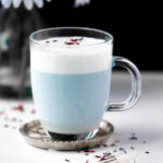 Photo of a Blue mermaid latte with foam and lavender flowers as garnish.