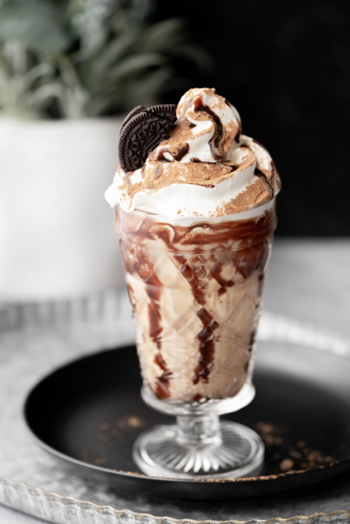 Hero shot of Oreo Iced Coffee drizzled with chocolate syrup. 