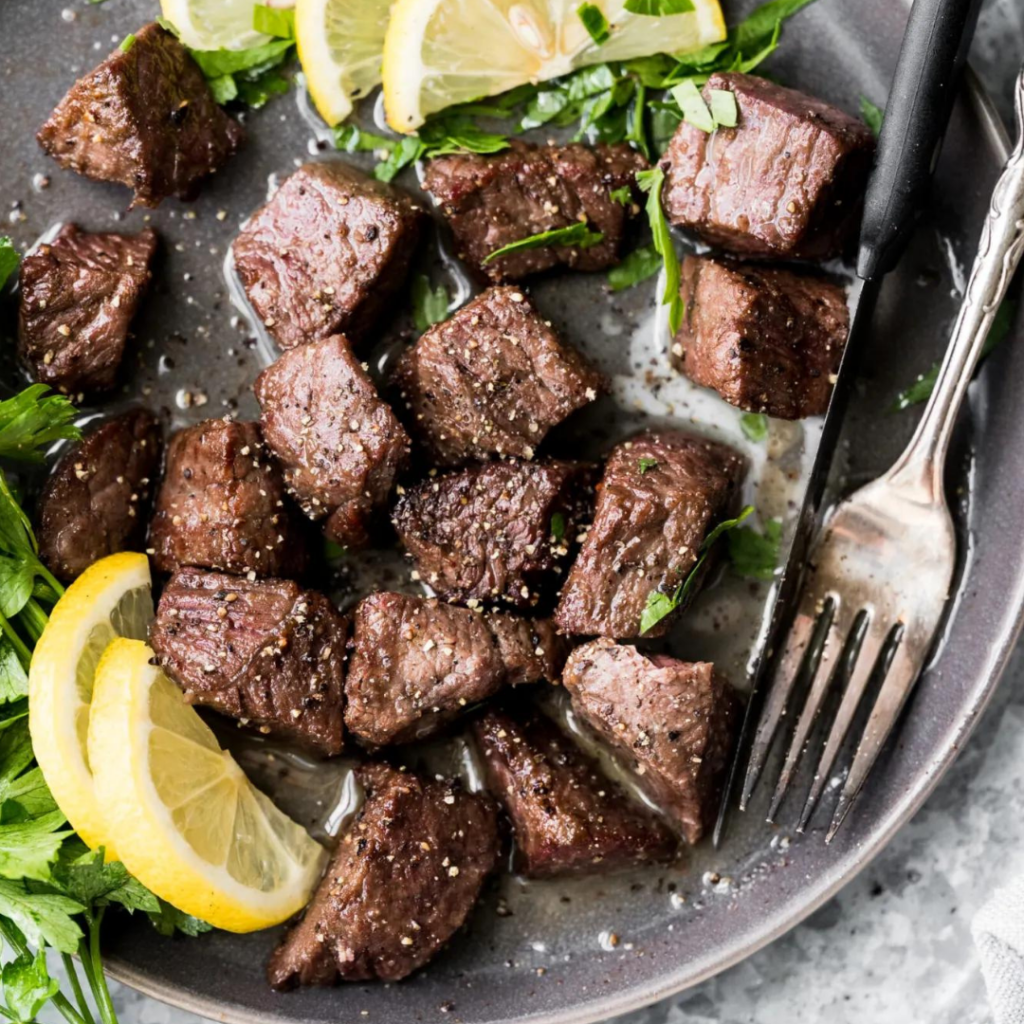 Instagram Dinner Caption Ideas: photo of cubed steak on a gray plate. 