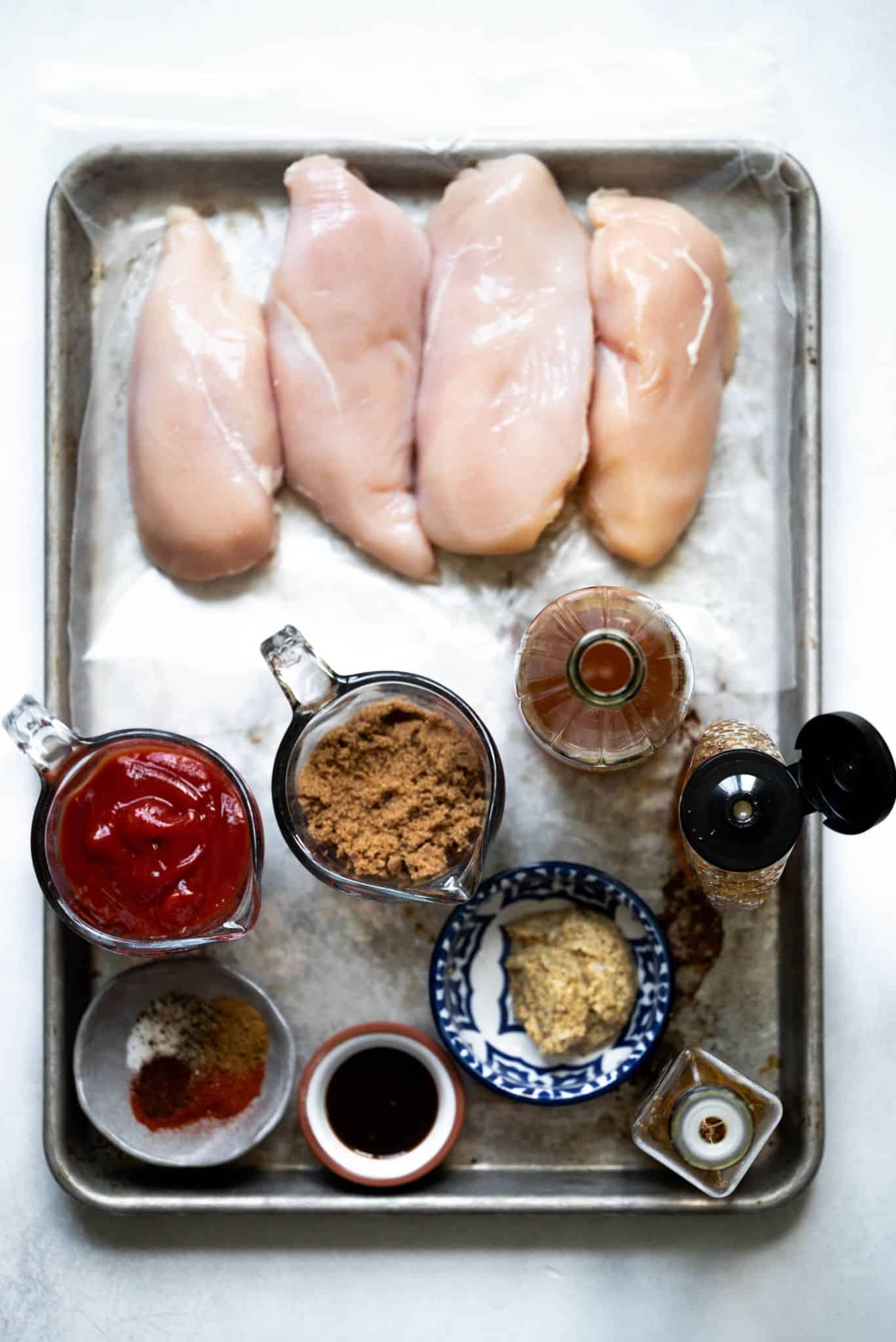 Ingredients on a sheet pan for bbq chicken.