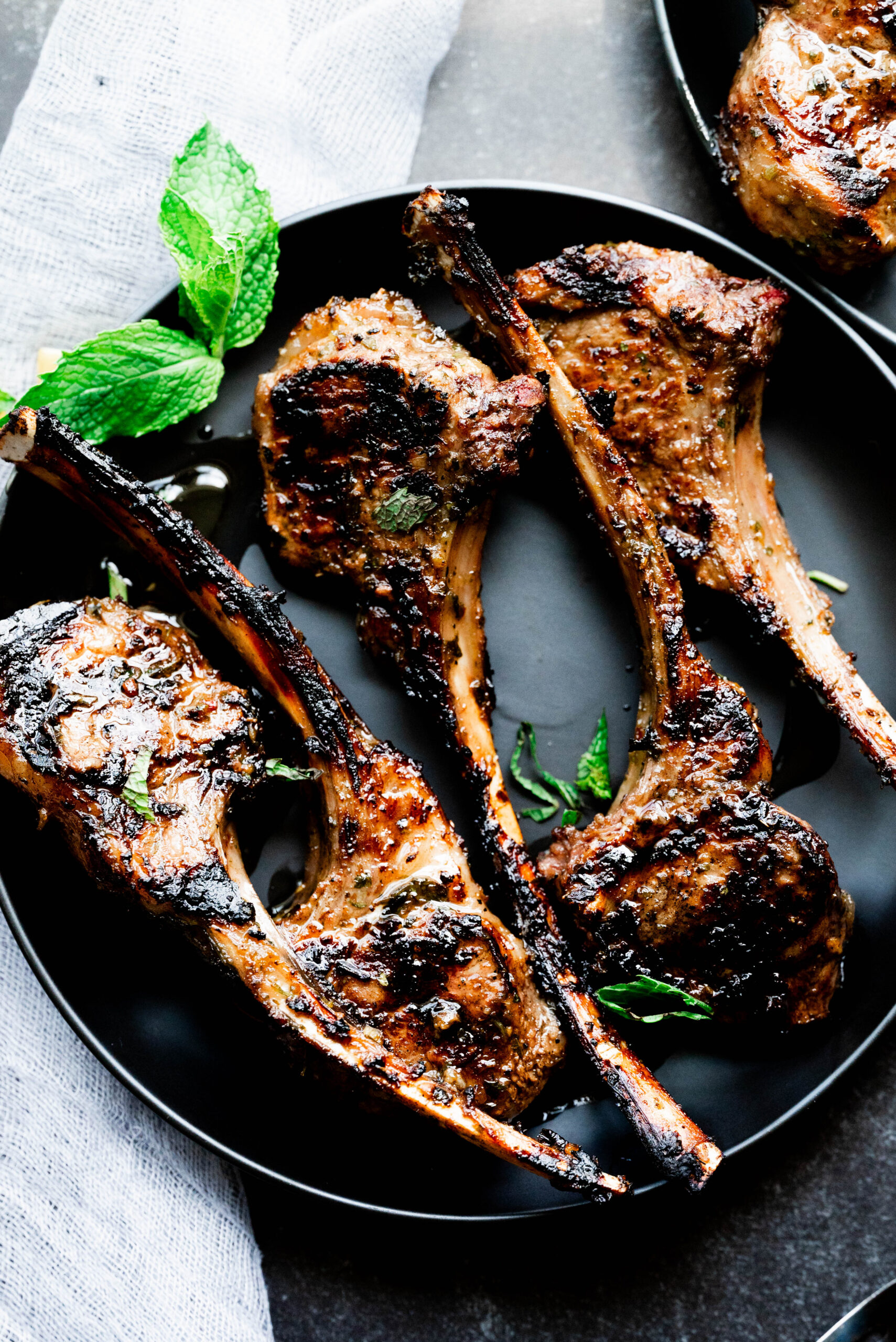 Lamb chops on a black plate. 