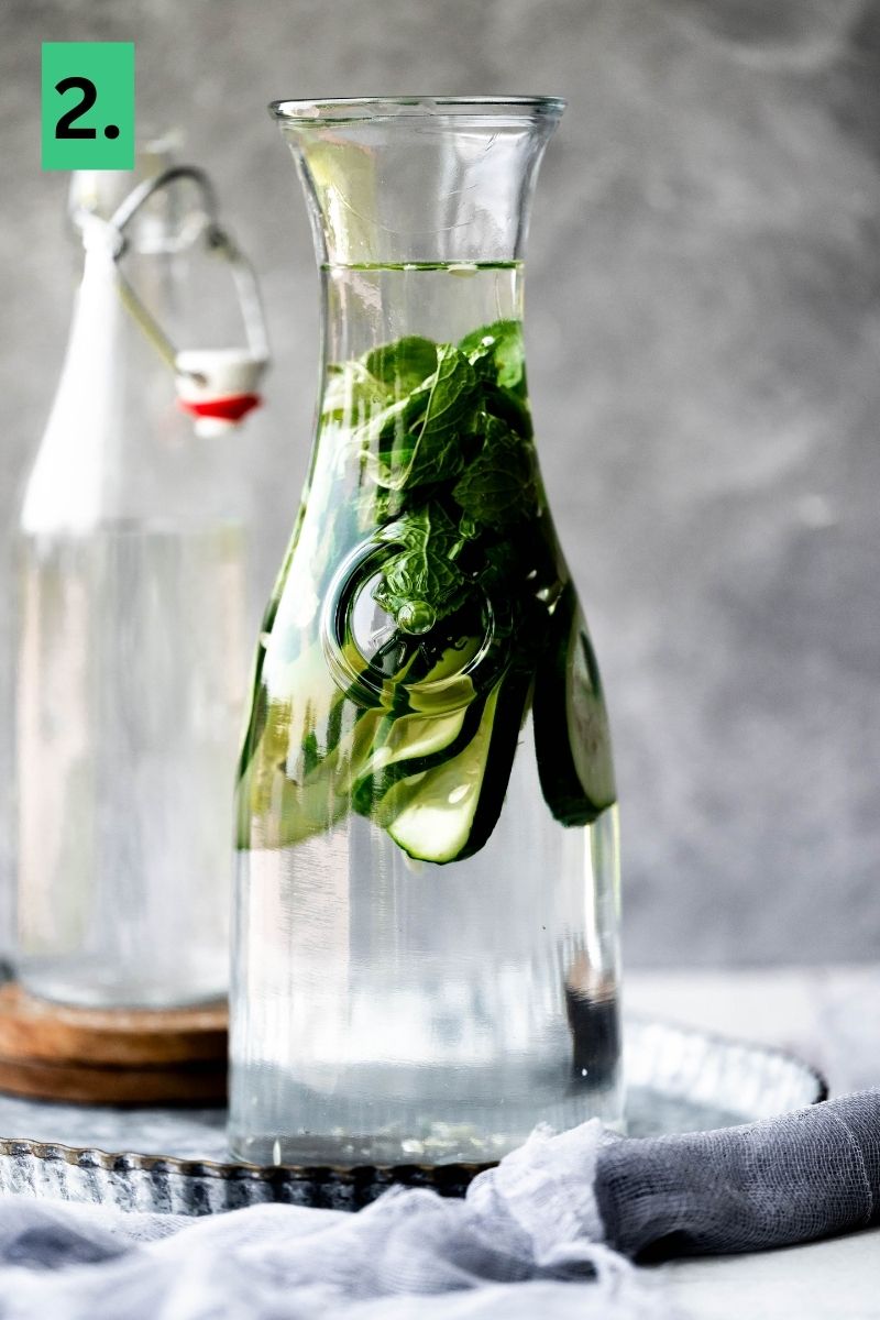 Water with mint and cucumbers in a pitcher. 