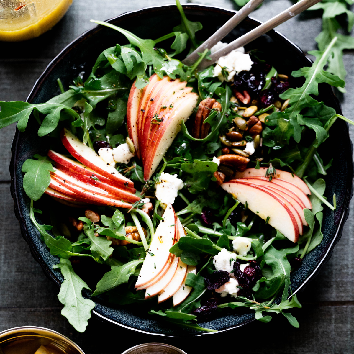 Overhead photo of apple salad with Arugula on a wooden background.  