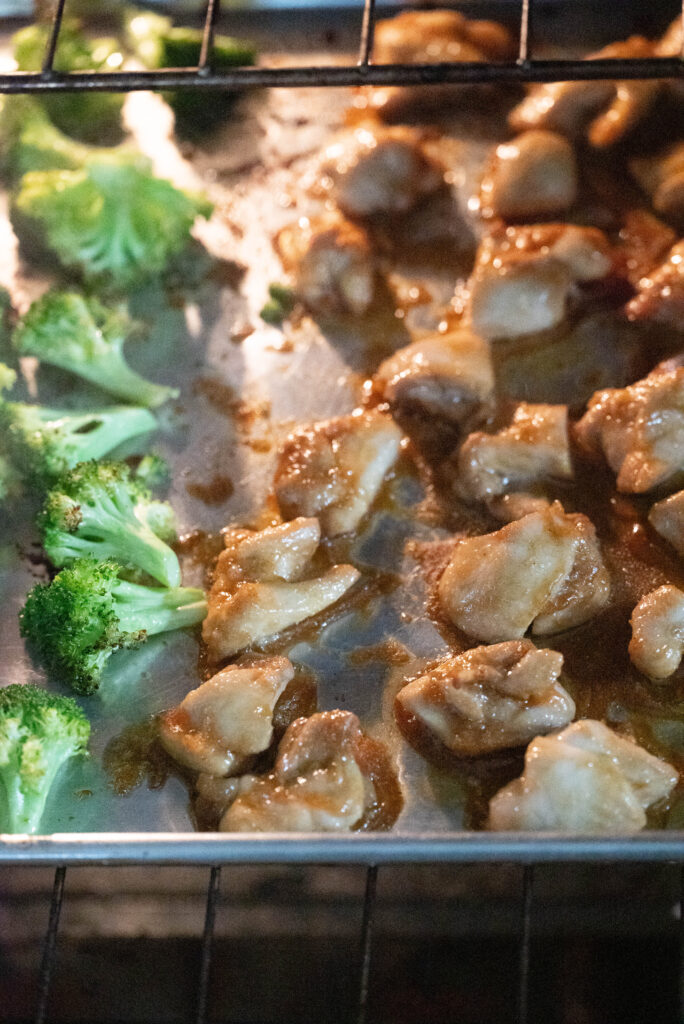 Photo of chicken and broccoli on a sheet pan. 