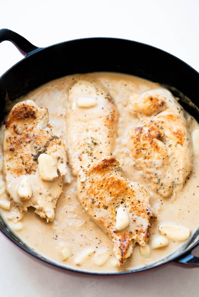 Chicken with garlic cream sauce in a pan. 