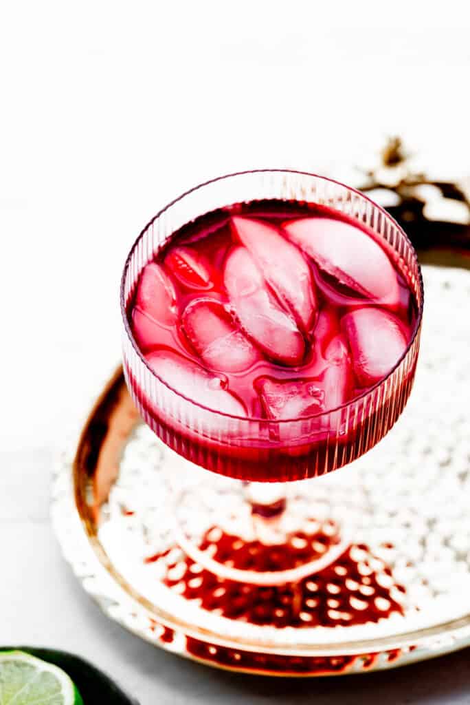 Process shot: hibiscus tea and ice in a pink glass. 