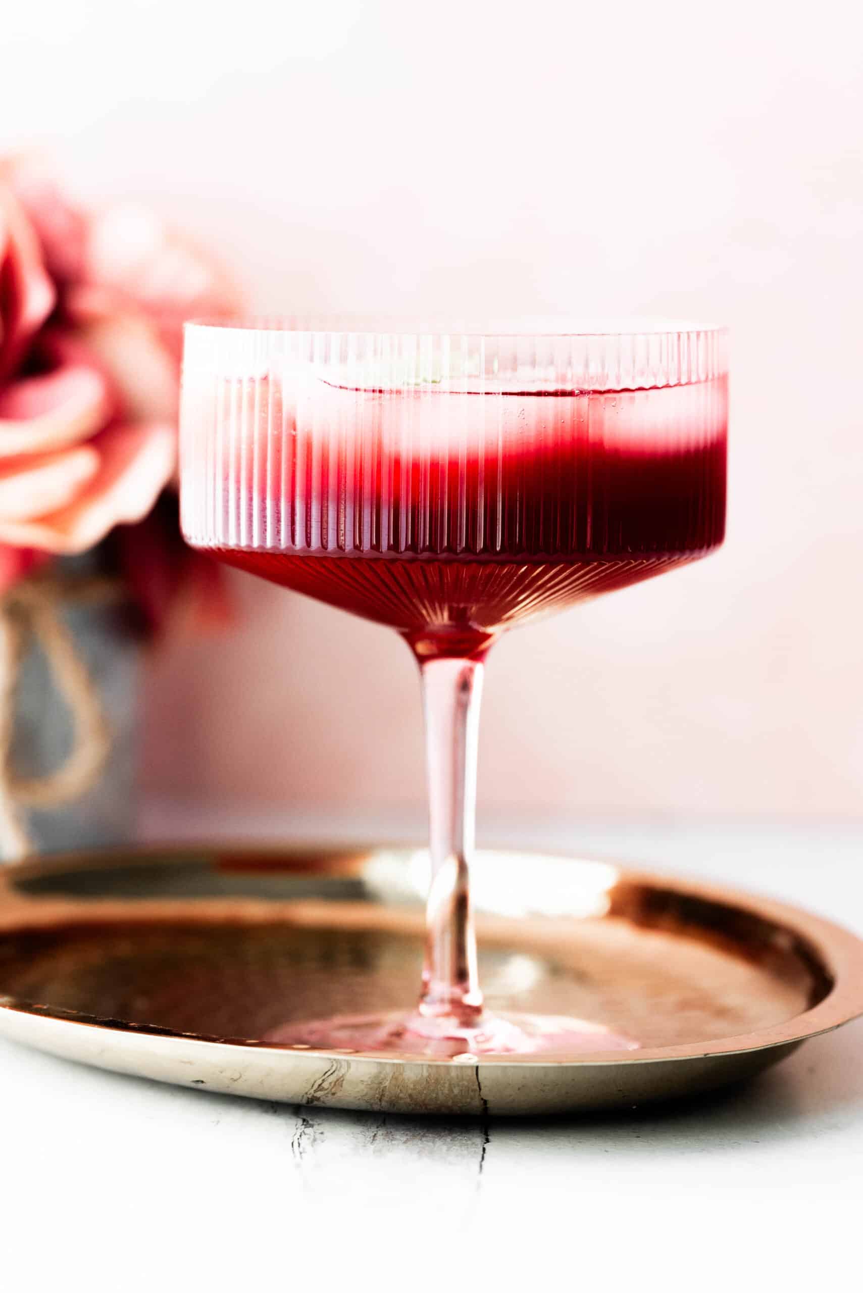 Mocktail in a pink glass with a pink background. 