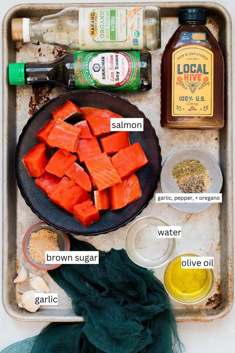 Ingredients needed to make honey garlic salmon bites on a sheet pan. 