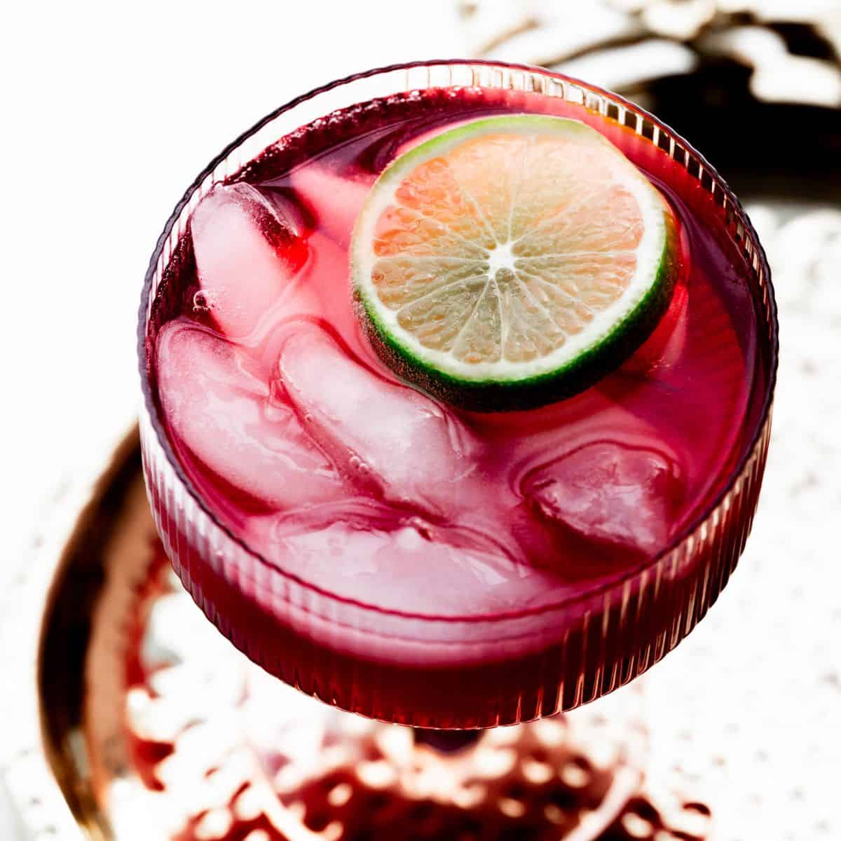 Overhead hero image of a tart cherry juice mocktail with a lime wedge.  