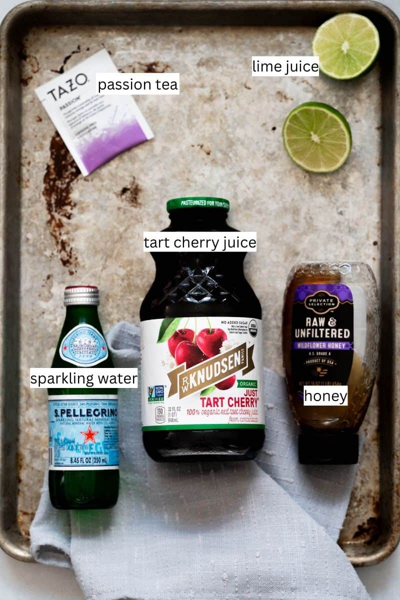 Labeled ingredients needed to make a relaxing tart cherry juice mocktail on a sheet pan. 