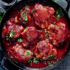 Overhead image of dutch oven chicken thighs with bbq sauce.