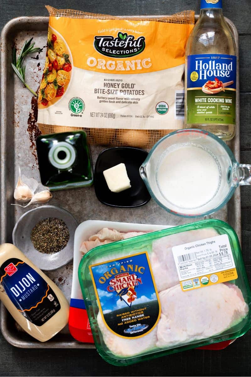 Ingredients on a sheet pan needed to make dutch oven chicken thighs. 