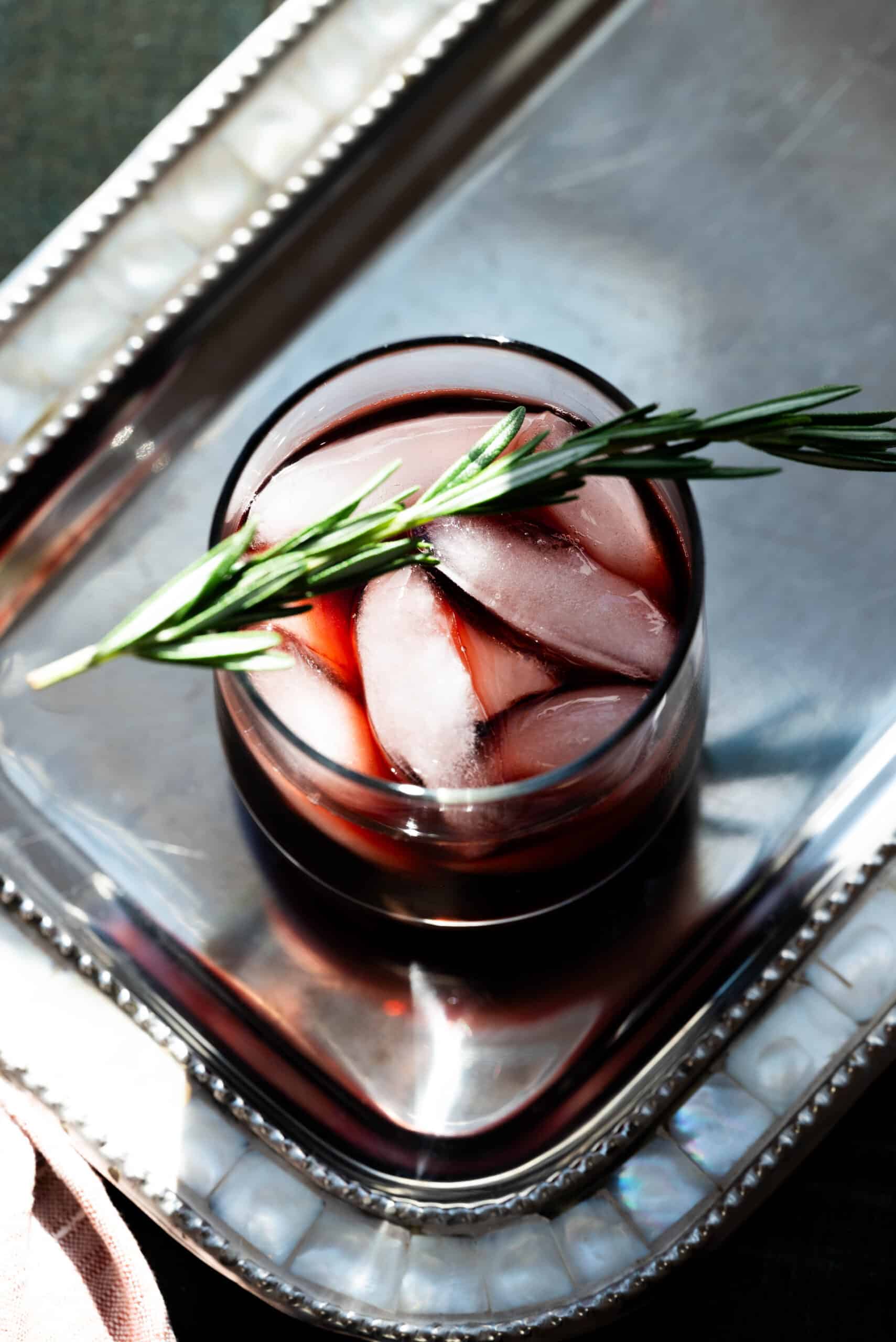 Overhead image of a kombucha mocktail with a rosemary sprig. 