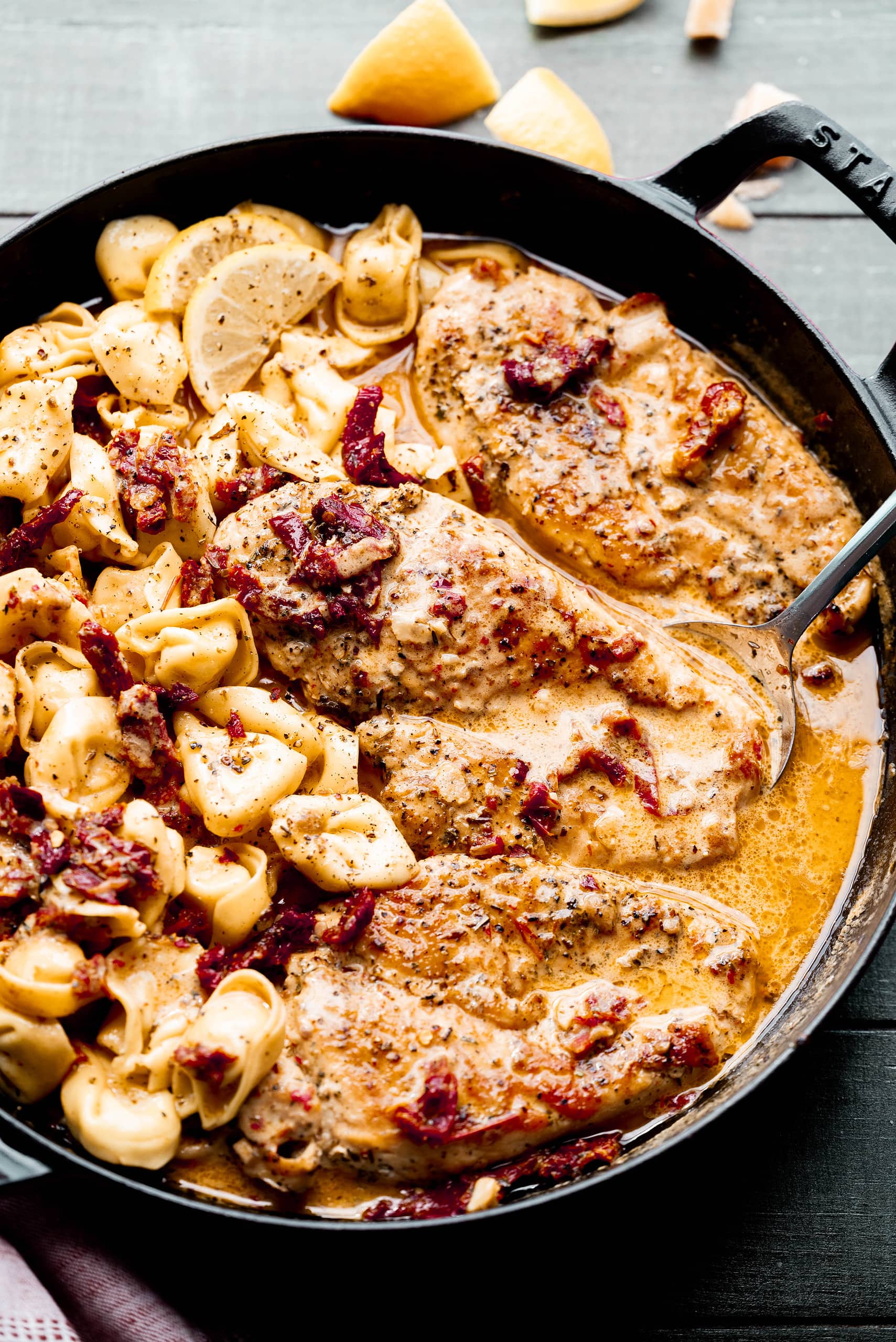 Chicken in a Staub Pan with lemon garnishes. 