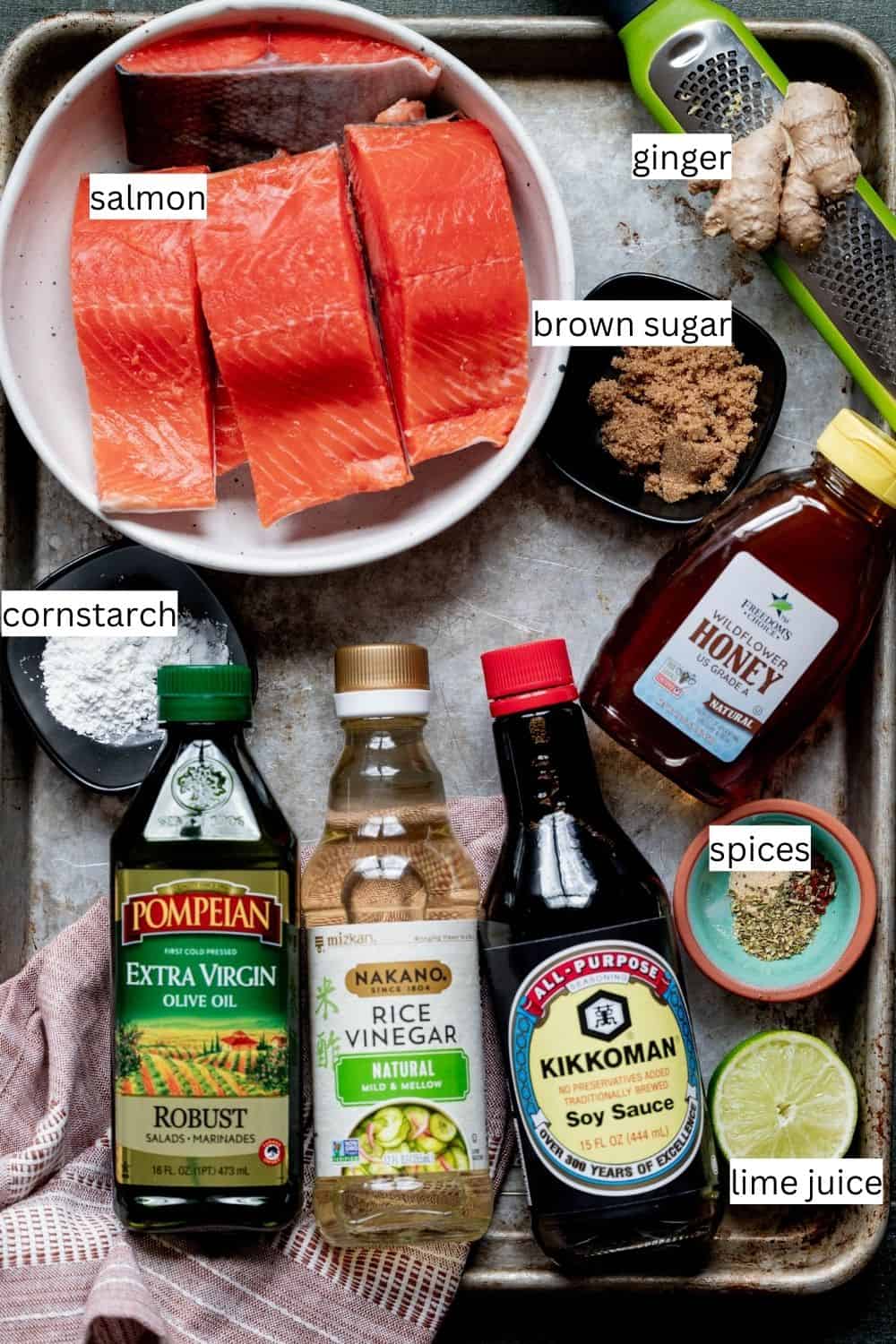Ingredients needed to make dutch oven salmon on a sheet pan with labels. 