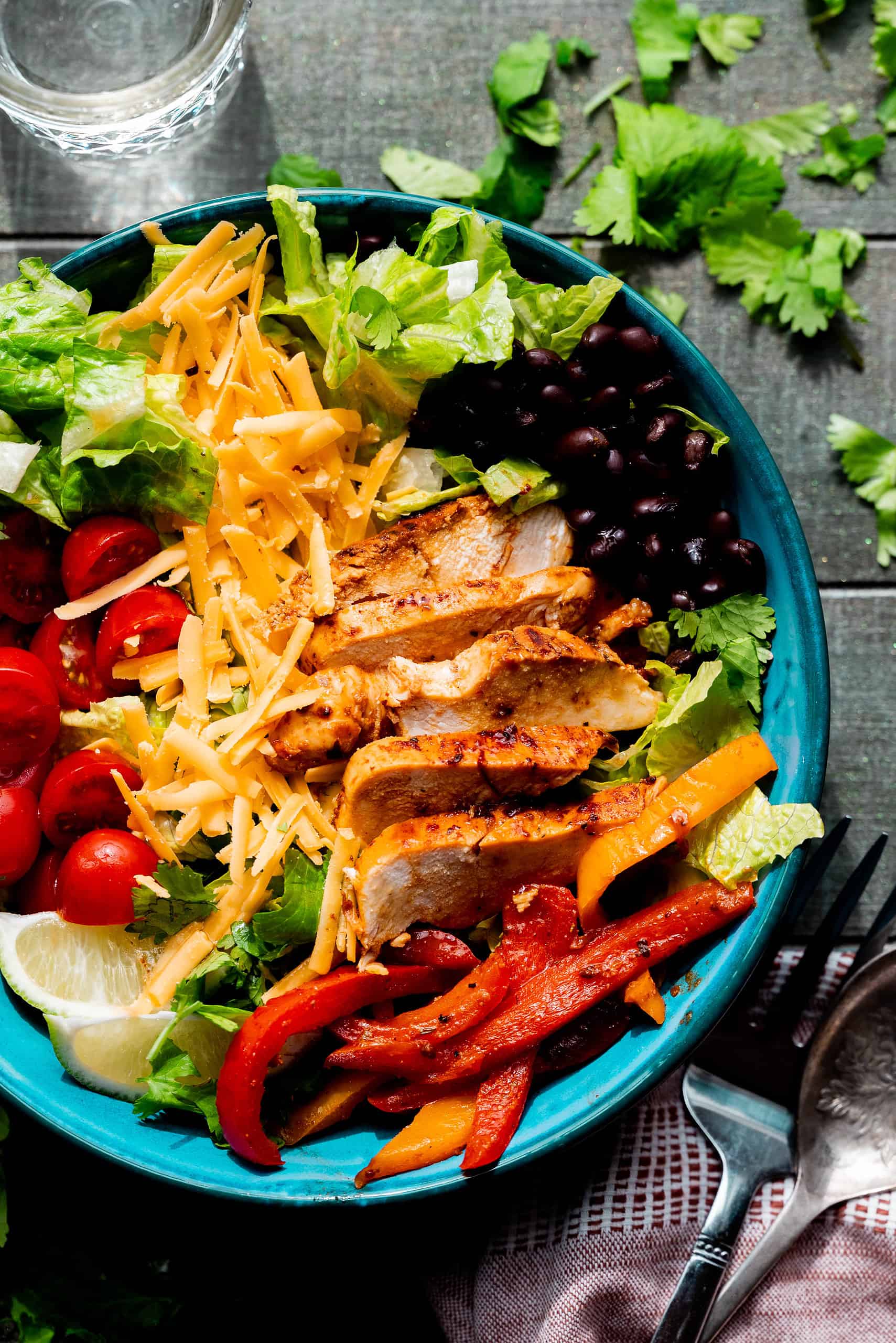 Side image of chicken fajita taco salad on a wooden background. 