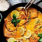 Hero Image of Yellow Coconut Curry Salmon in a black pan.