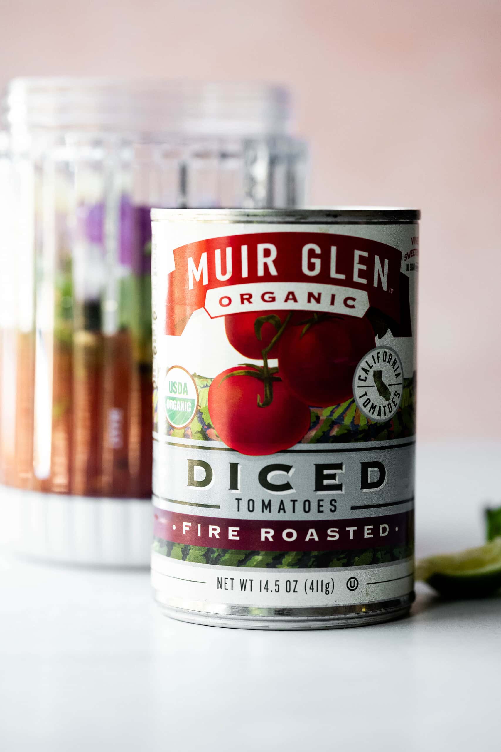 Muir Glen can of tomatoes with the fire roasted tomato salsa in a blender in the background. 