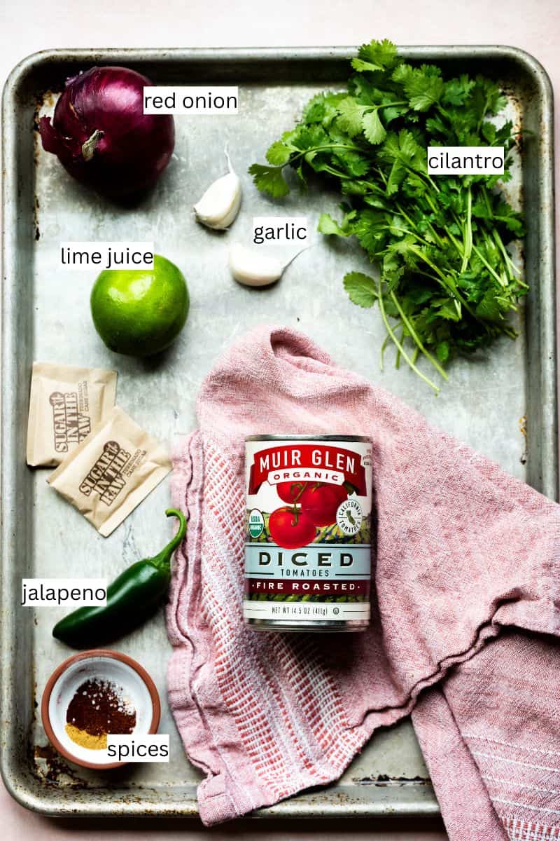 Ingredients needed to make fire roasted tomato salsa on a sheet pan. 