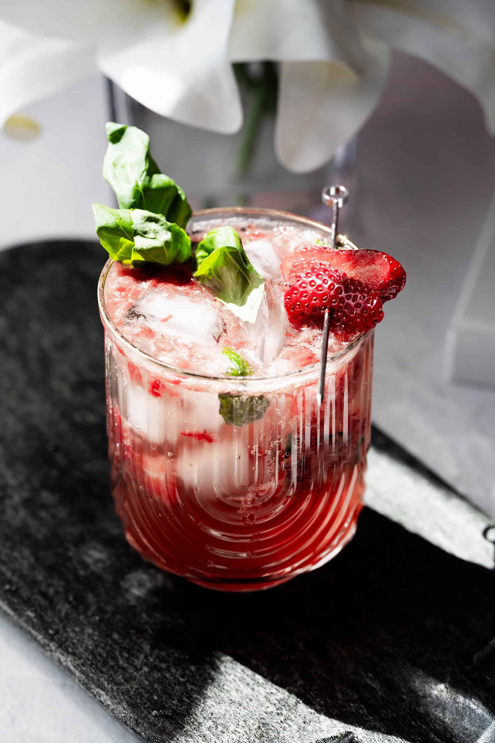 Overhead image of a strawberry mocktail on a black board. 