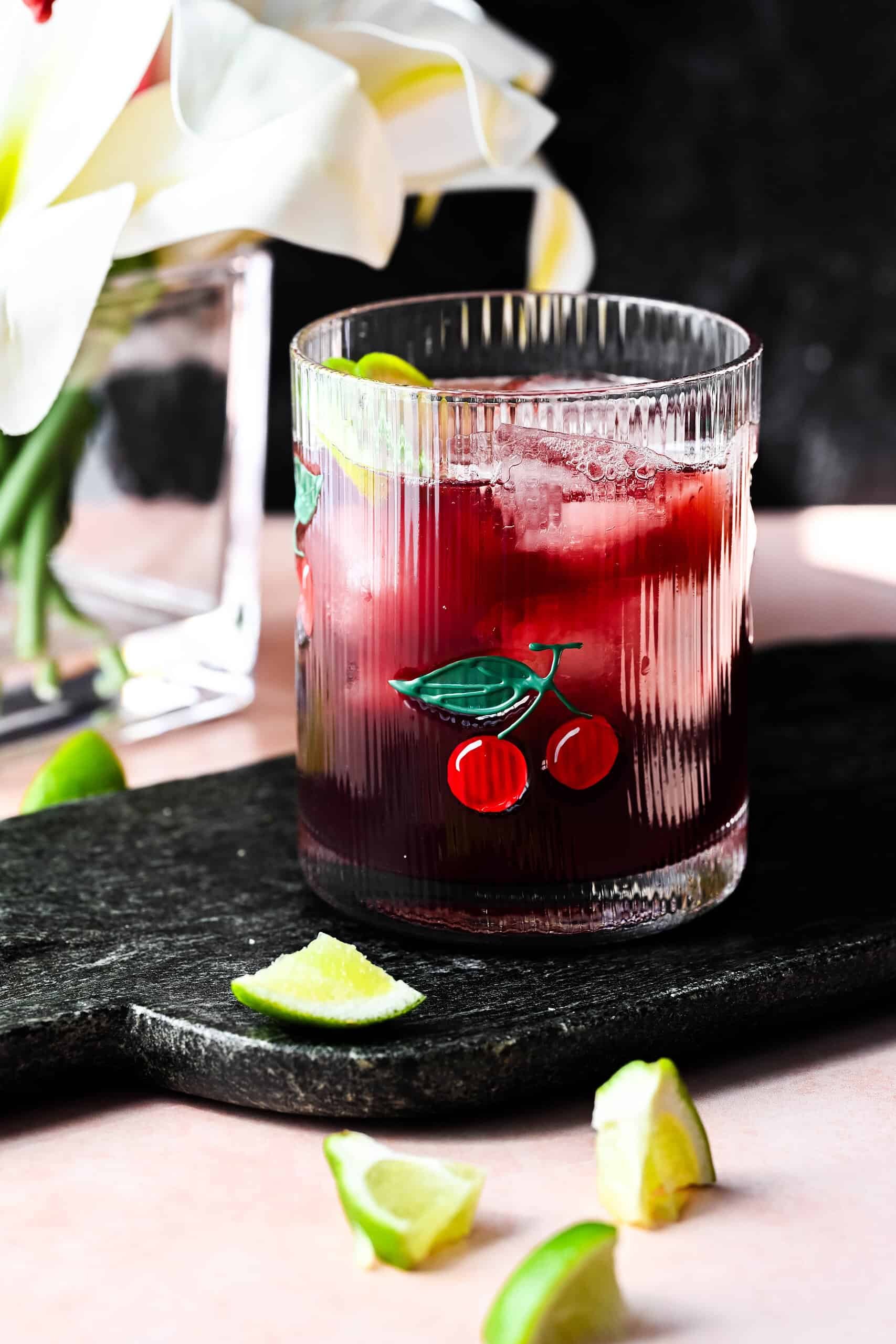 Hero image of tart cherry mocktail with lime wedges. 