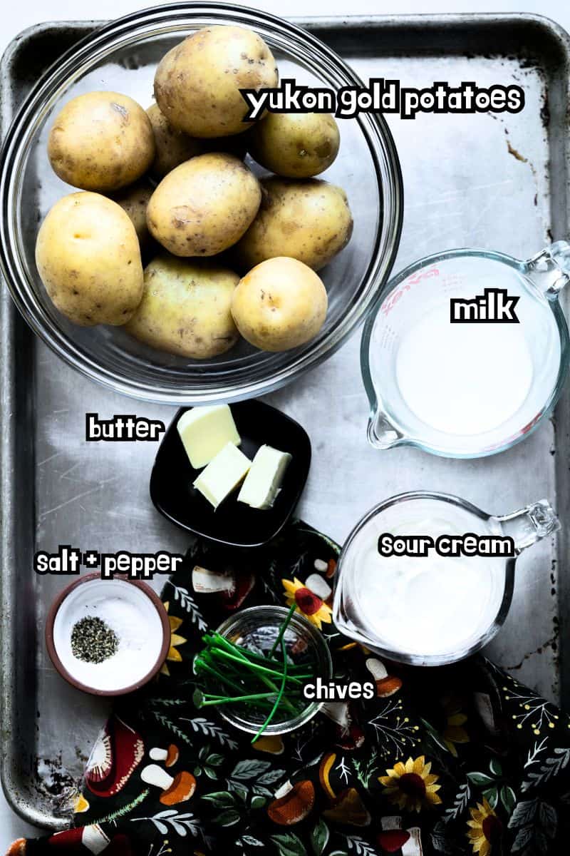 Ingredients on a sheet pan for chive and sour cream mashed potatoes. 