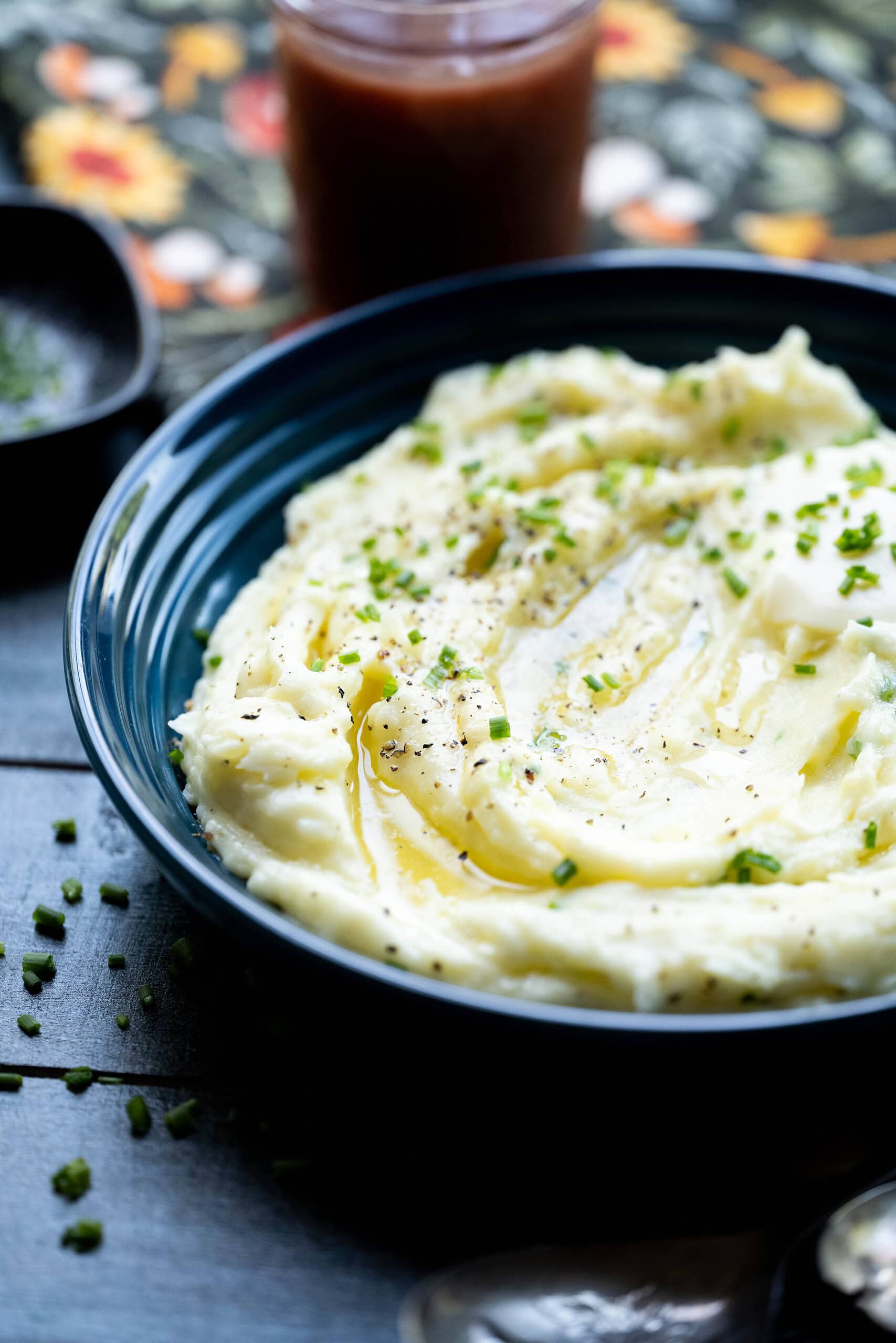 Overhead image of mashed potatoes in a blue bowl with chives. 