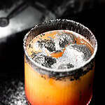 Mocktail with silver glitter and a black rim.