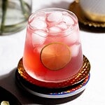 Hero image of the drink with a lime garnish on a coaster.