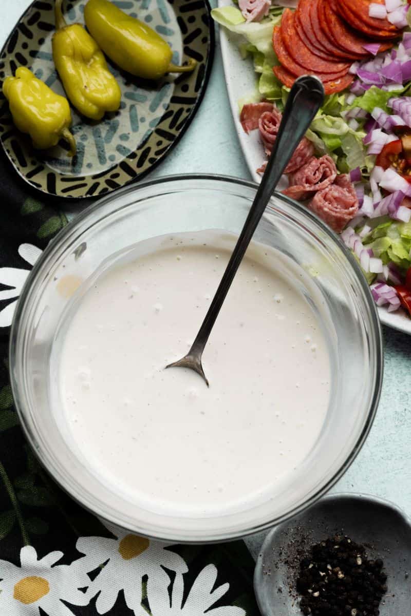 Overhead dark image of salad dressing in a clear bowl.