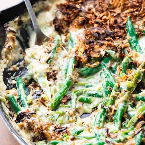 Close up image of green bean casserole with a spoon.