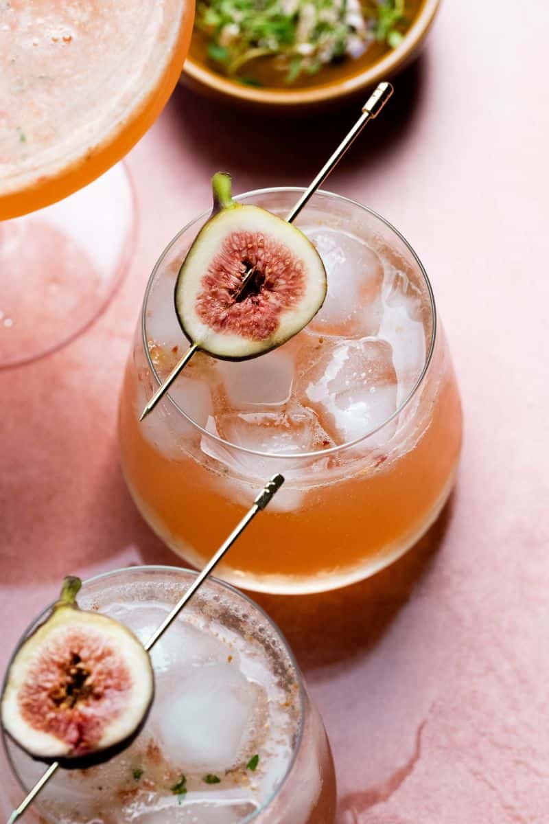 Overhead image of a drink with a fig and cocktail pick.