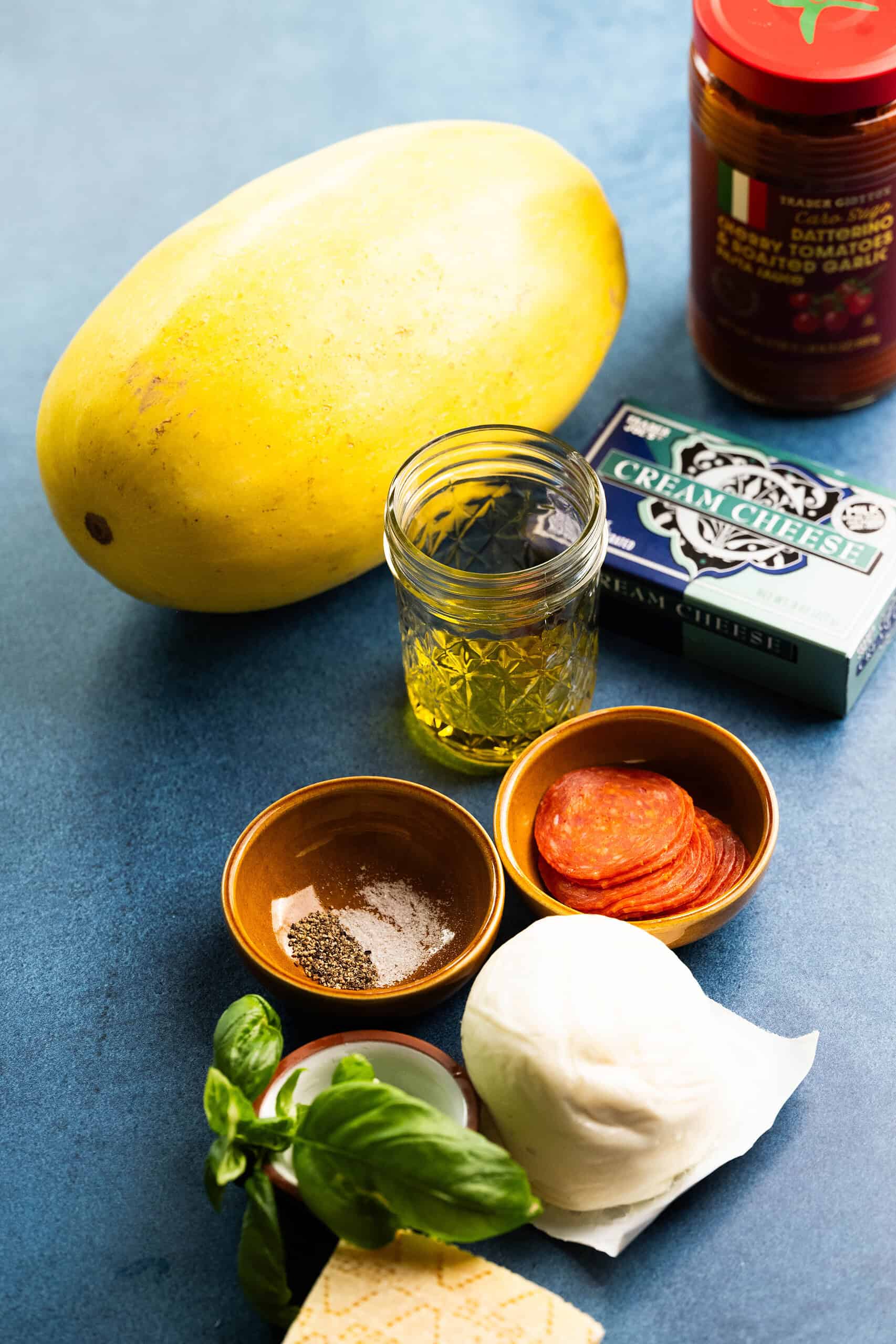 This is the ingredients on a background that's blue--to make pizza spaghetti squash.