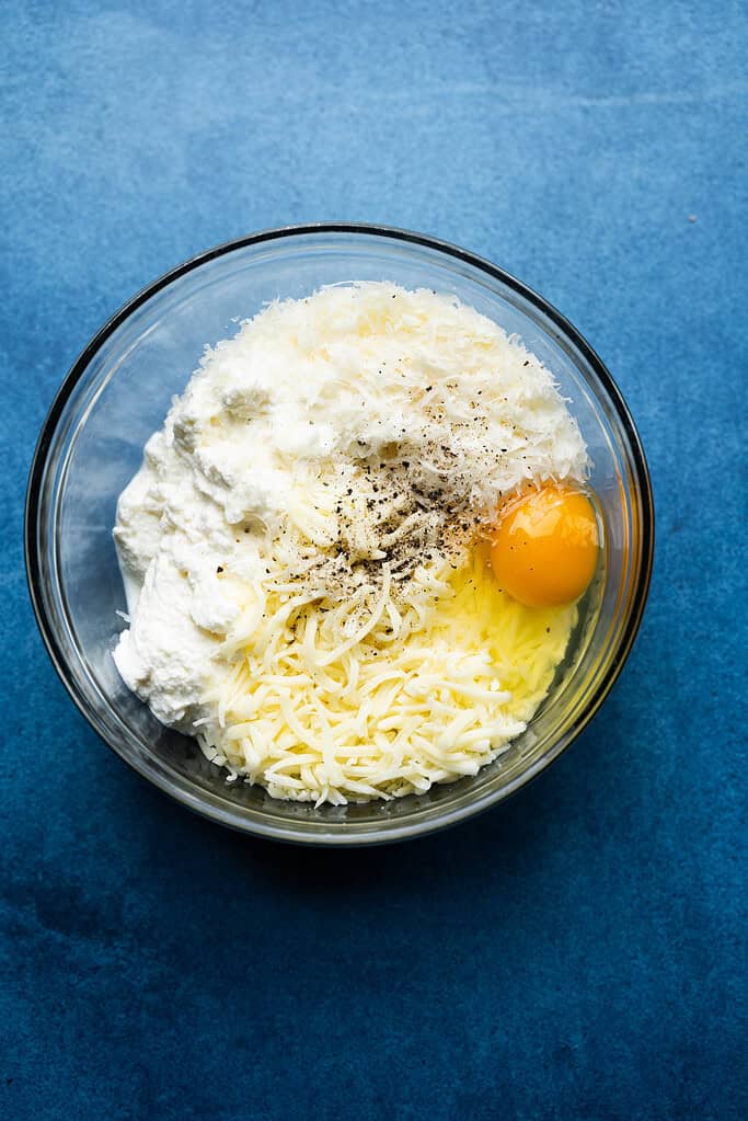 Cheese in a bowl with an egg.