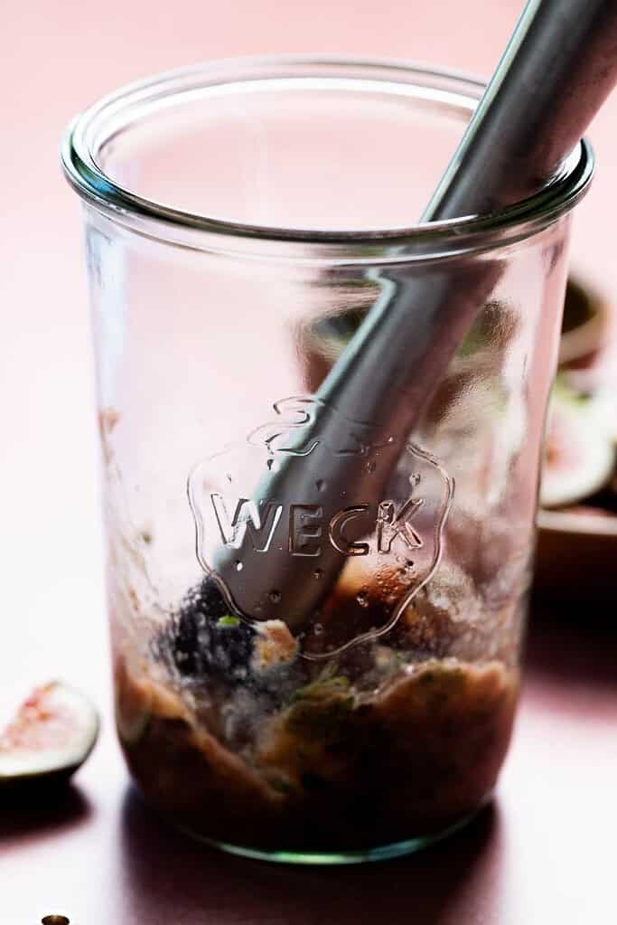 close up image of a jar and a muddler.